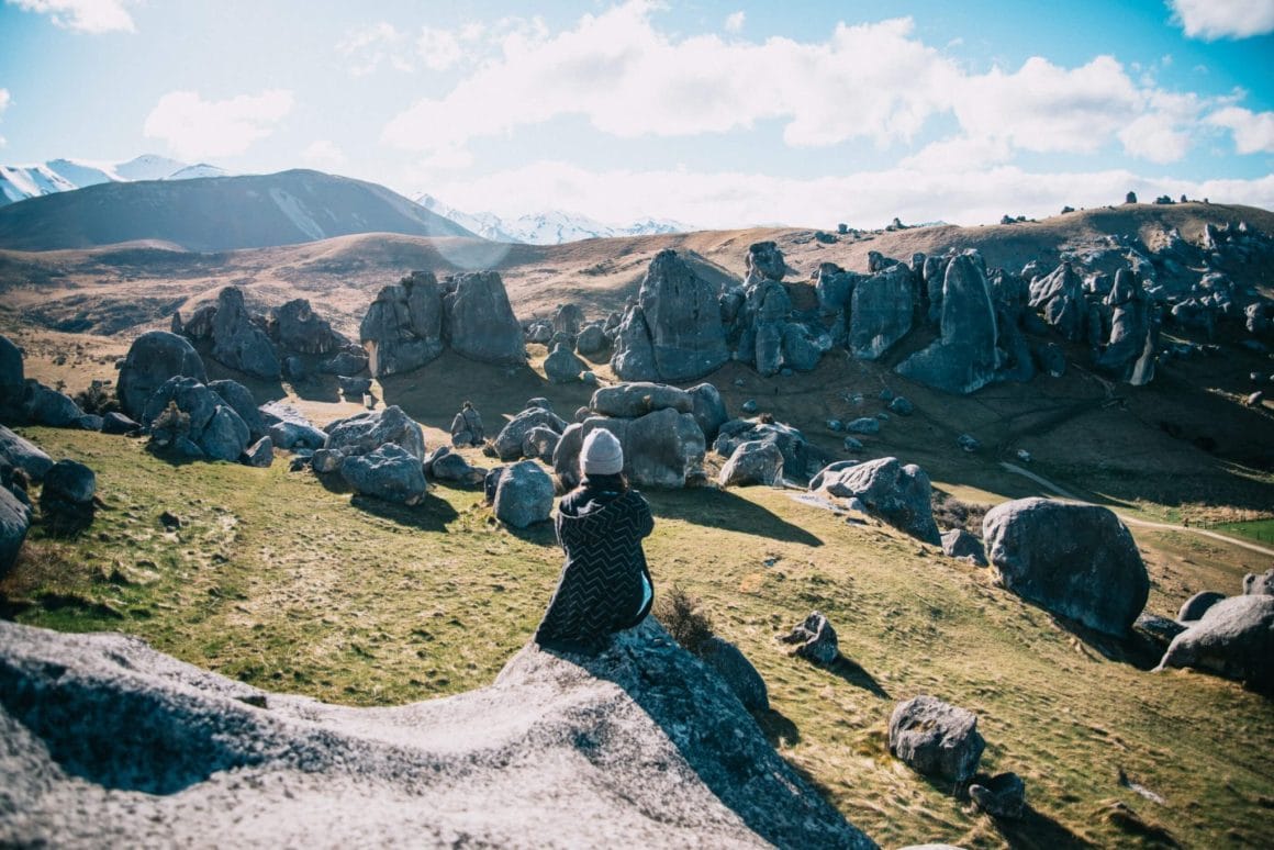 Achterkant van persoon die over de boulders kijkt