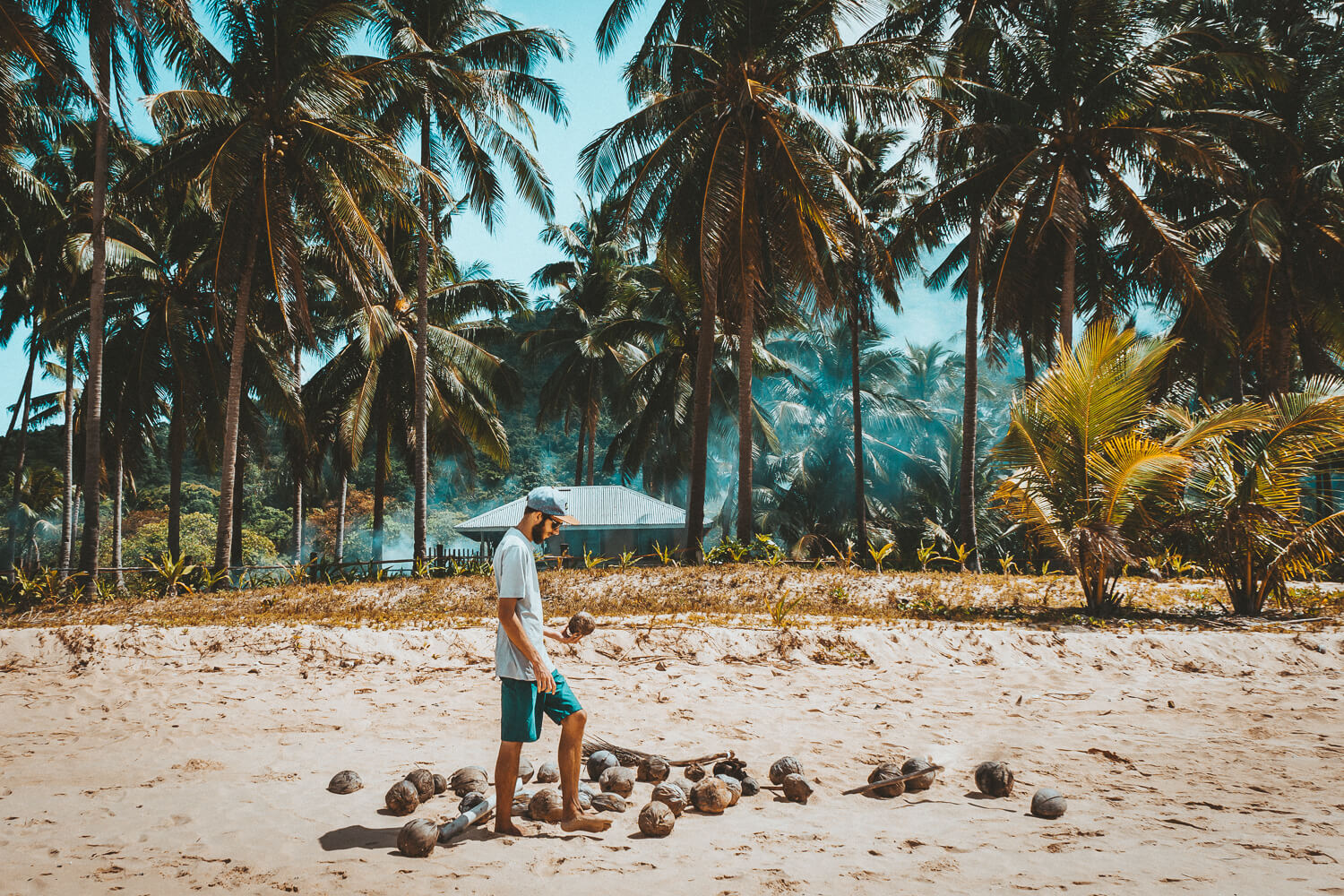 man met kokosnoot op het strand