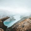 reisblogger stel bovenop de trolltunga rotsformatie met uitzicht over de fjorden