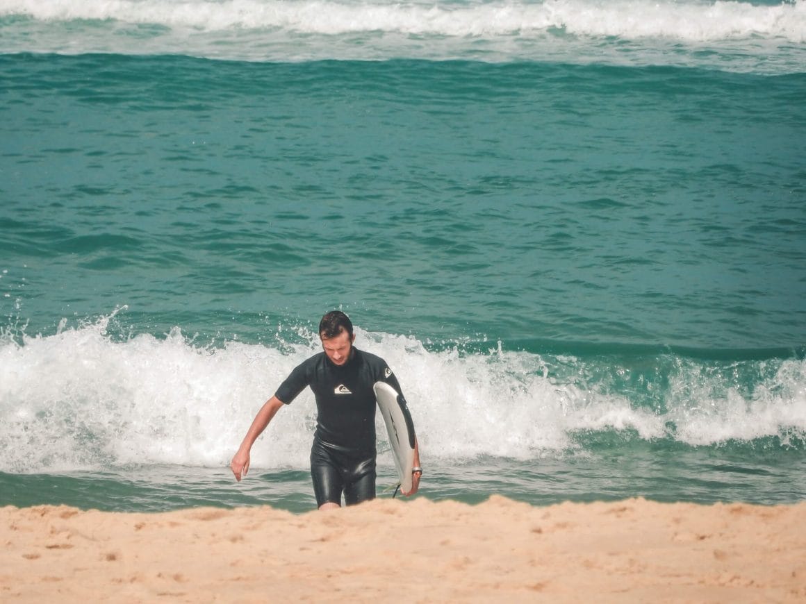 Lone surfer die uit het water komt