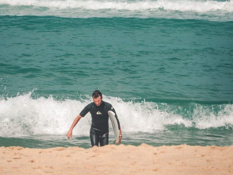 Lone surfer die uit het water komt
