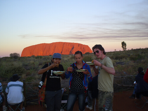 Backpackers die eten bij zonsondergang Ayers Rock